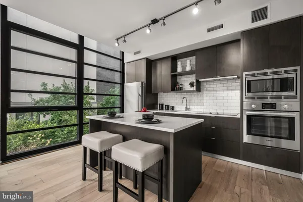 a kitchen with a sink and chairs