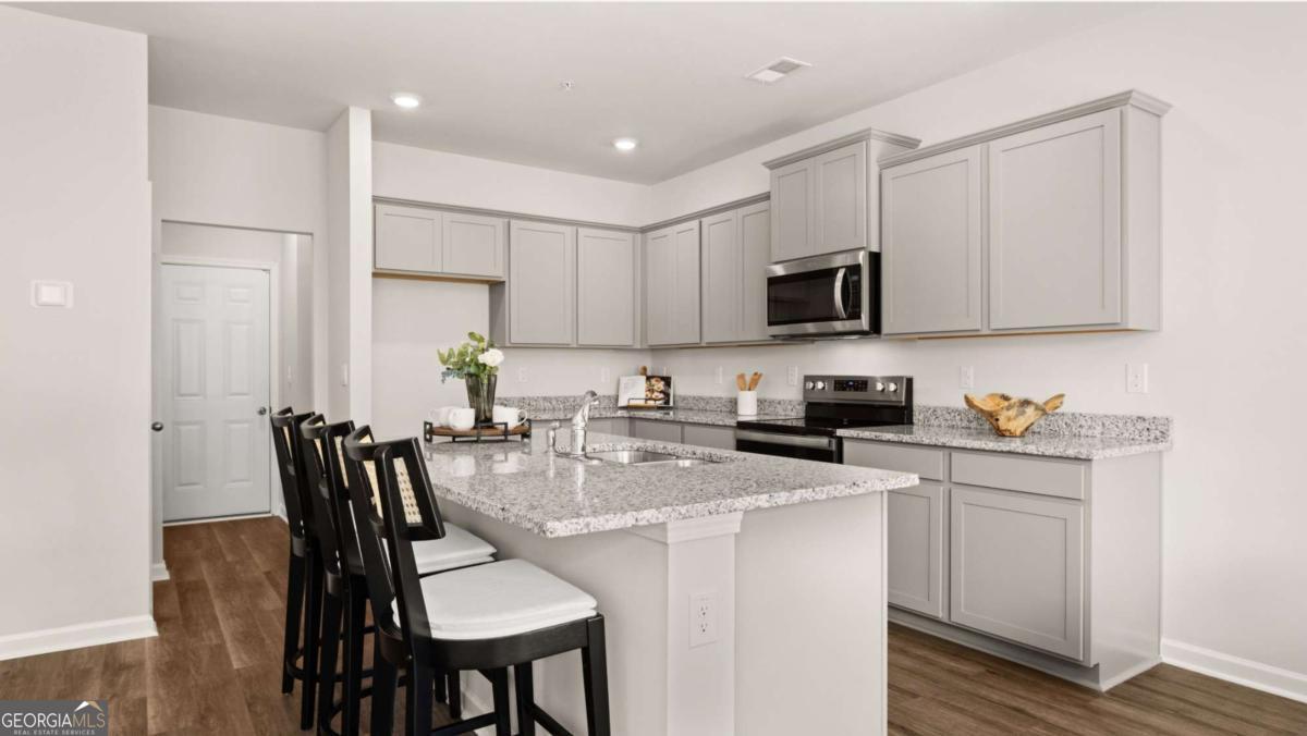 237 Sound Circle Stockbridge, GA 30281 - Photo 65 of 67 a kitchen with stainless steel appliances granite countertop a stove a sink a dining table and chairs