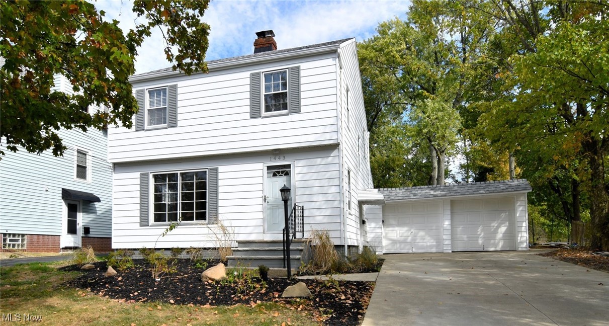 Colonial house featuring a garage and a chimney