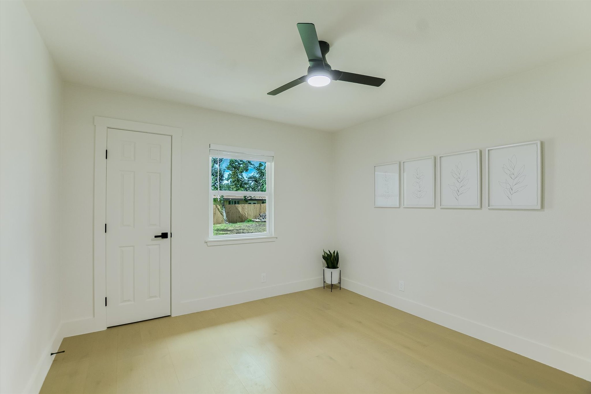 4505 Kitty Avenue Austin, TX 78721 - Photo 8 of 11 A quiet bedroom featuring light engineered wood flooring and a contemporary ceiling fan for year-round comfort.