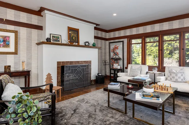 a living room with furniture fireplace and a large window