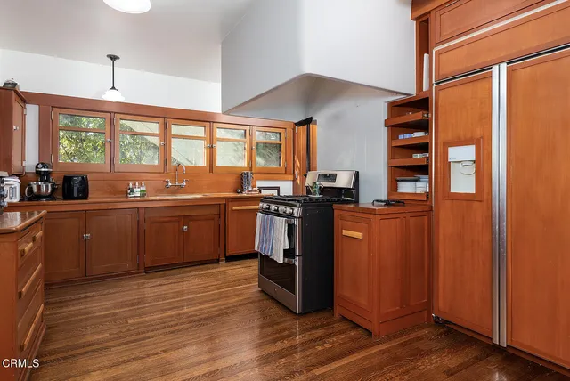 a kitchen with stainless steel appliances kitchen island granite countertop a sink cabinets and wooden floor