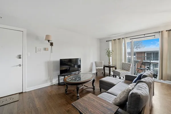 a living room with furniture wooden floor and a flat screen tv