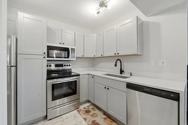 a kitchen with cabinets stainless steel appliances and a counter space