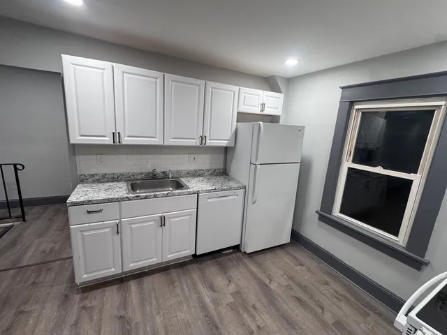 a kitchen with a refrigerator sink and cabinets