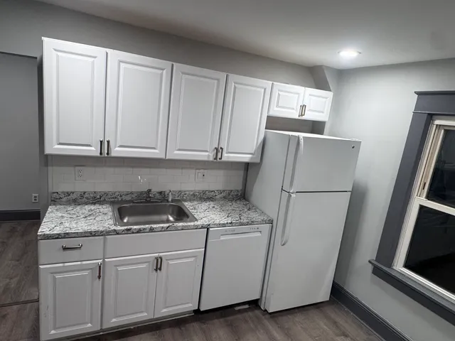 a kitchen with a refrigerator sink and cabinets