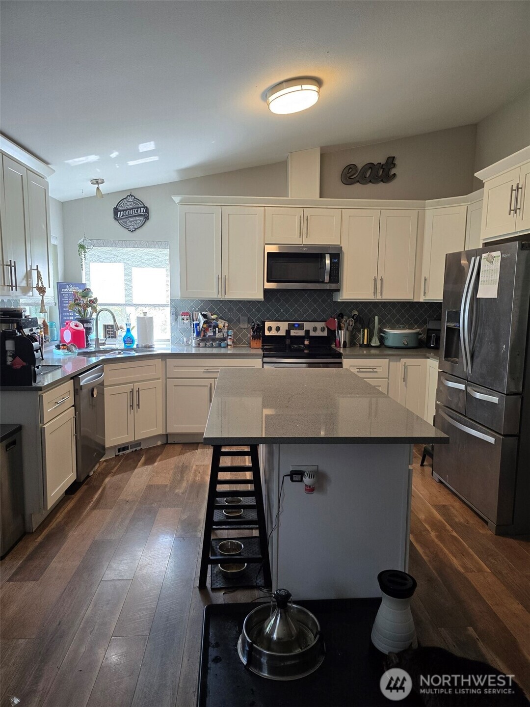 6611 Crescent Beach Road Northwest Vaughn, WA 98394 - Photo 8 of 17 a kitchen with stainless steel appliances a sink a stove a microwave a refrigerator and cabinets