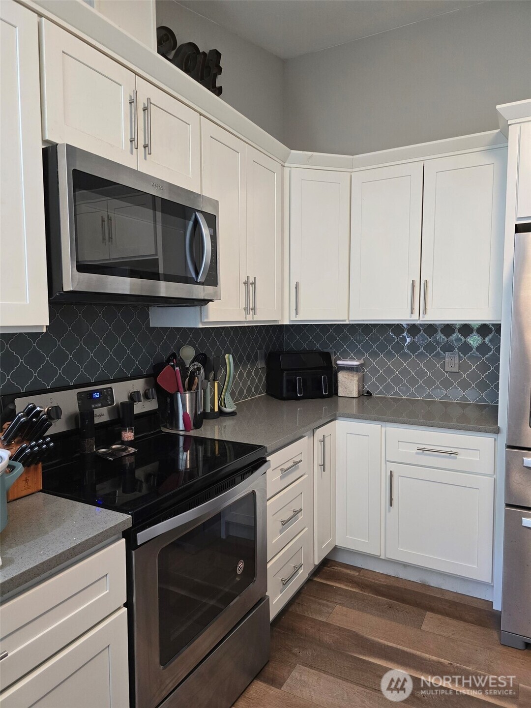 6611 Crescent Beach Road Northwest Vaughn, WA 98394 - Photo 10 of 17 a kitchen with stainless steel appliances granite countertop white cabinets a stove a sink and dishwasher
