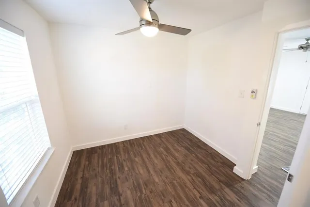 a view of a small space with wooden floor and a window