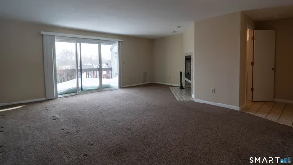 a view of an empty room with window and stairs