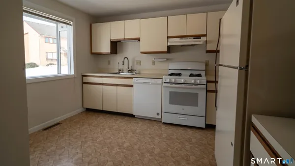 a kitchen with cabinets appliances and a window
