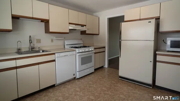 a kitchen with a refrigerator sink stove and cabinets