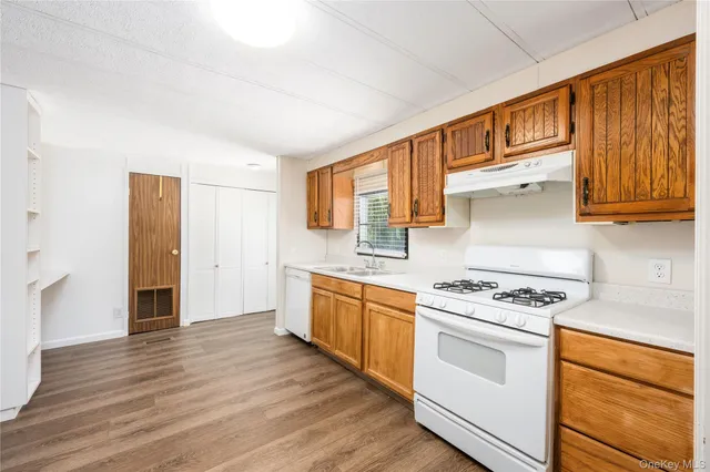 a kitchen with stainless steel appliances granite countertop wooden cabinets stove top oven and sink