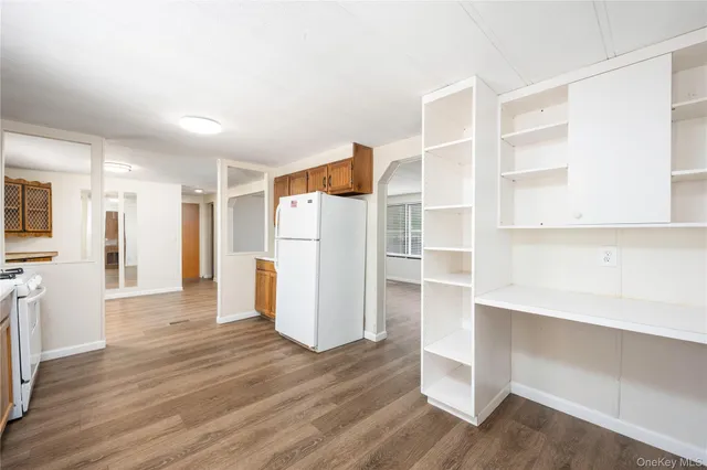 a view of a kitchen with wooden floor and a refrigerator