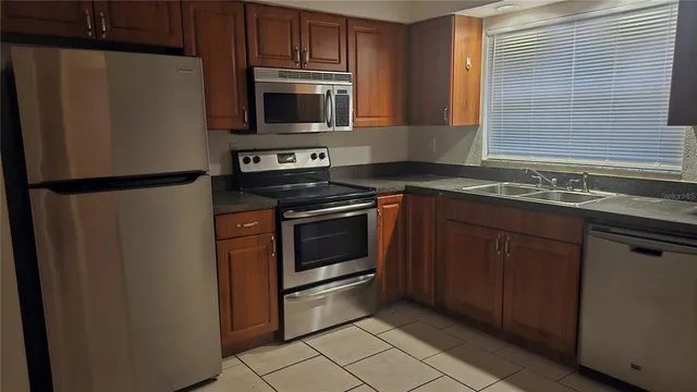a kitchen with stainless steel appliances a stove a microwave and a sink
