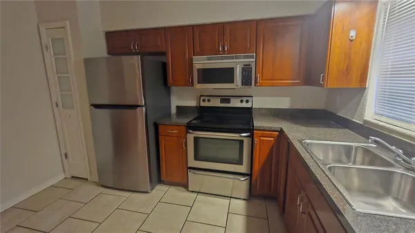 a kitchen with granite countertop a refrigerator and a sink
