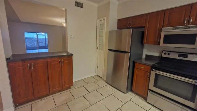 a kitchen with stainless steel appliances granite countertop a refrigerator and a stove top oven