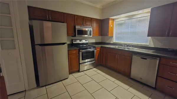 a kitchen with stainless steel appliances granite countertop a refrigerator and a sink