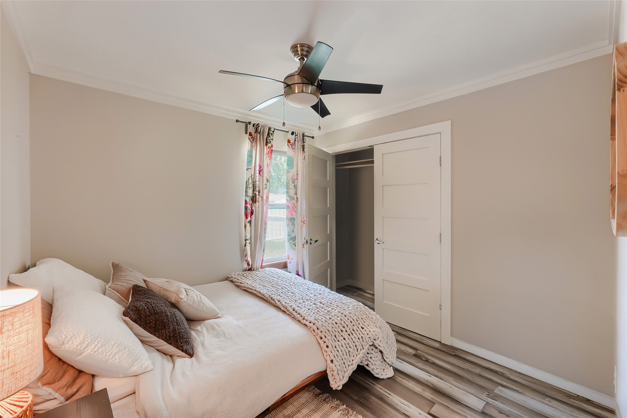 5707 Tracy Lynn Lane, Unit A Austin, TX 78721 - Photo 21 of 33 Bedroom with ornamental molding, ceiling fan, a closet, and light wood-style floors