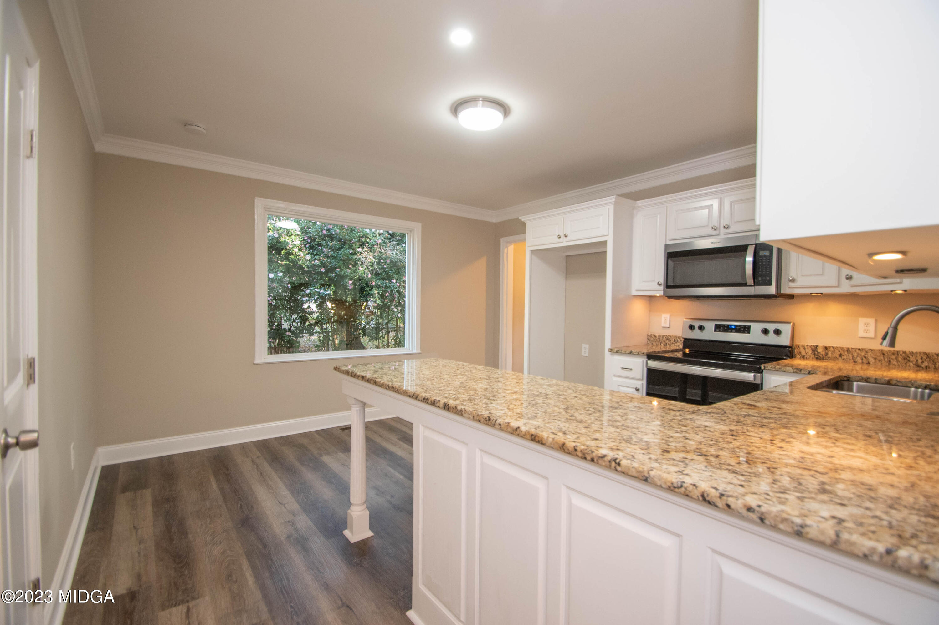 225 R Street Northwest Thomaston, GA 30286 - Photo 12 of 22 a kitchen with granite countertop a stove a sink and a microwave