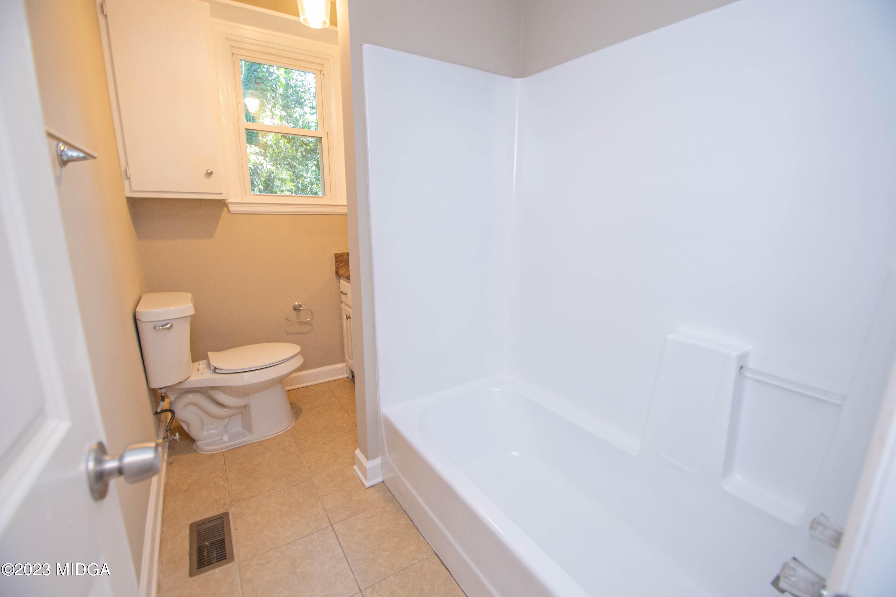 225 R Street Northwest Thomaston, GA 30286 - Photo 17 of 22 a white toilet sitting next to a bath tub