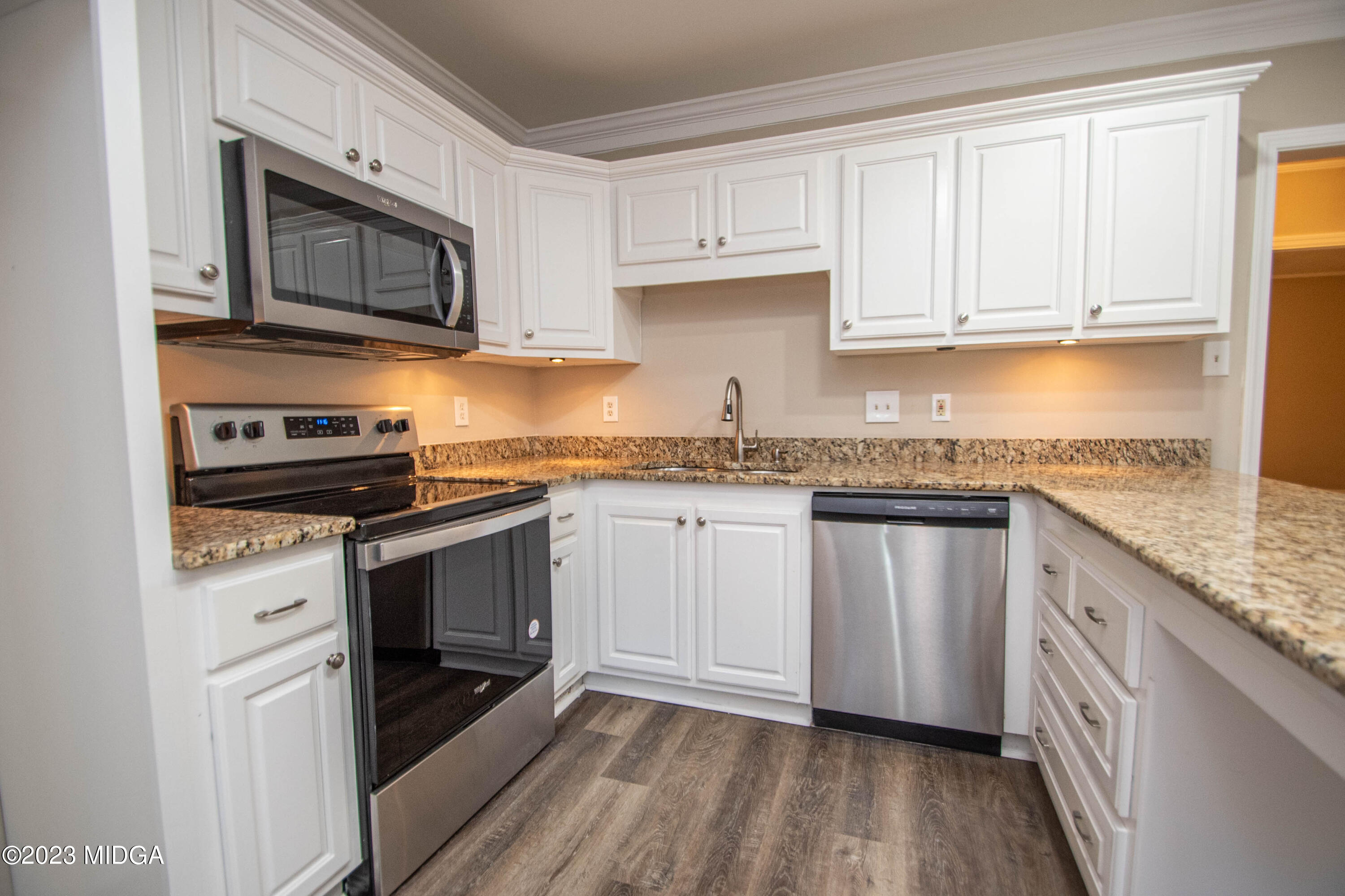 225 R Street Northwest Thomaston, GA 30286 - Photo 2 of 22 a kitchen with granite countertop a sink a stove top oven and cabinetry