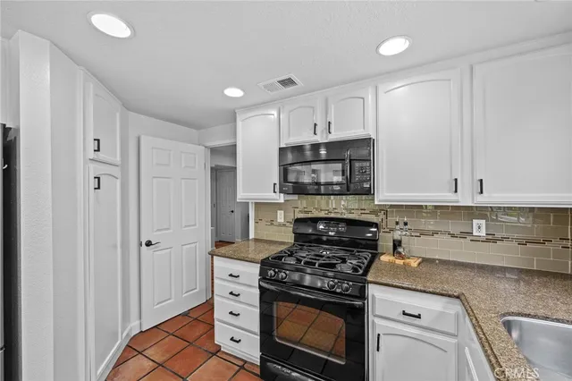 a kitchen with stainless steel appliances granite countertop a stove and a refrigerator