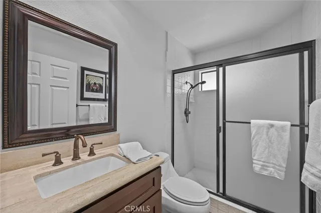 a bathroom with a granite countertop sink toilet and shower