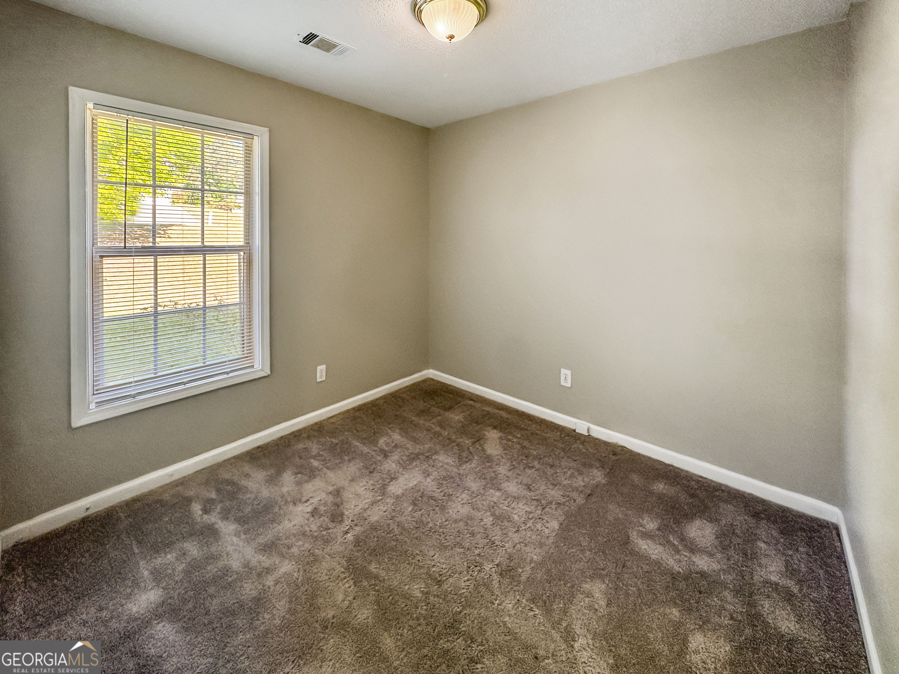 11084 Knotty Pine Place Hampton, GA 30228 - Photo 14 of 18 an empty room with windows