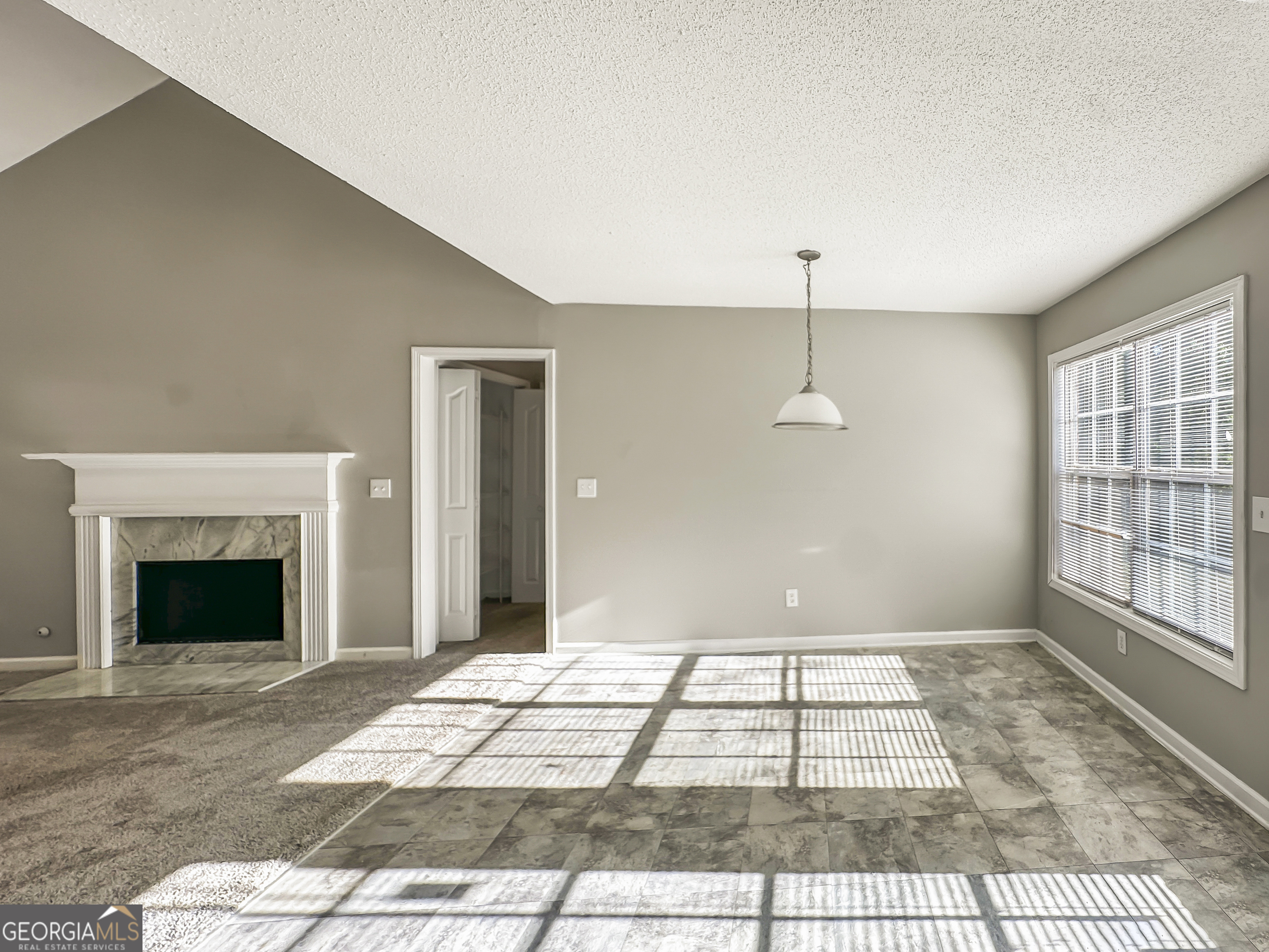 11084 Knotty Pine Place Hampton, GA 30228 - Photo 5 of 18 a view of an empty room with a fireplace and a window