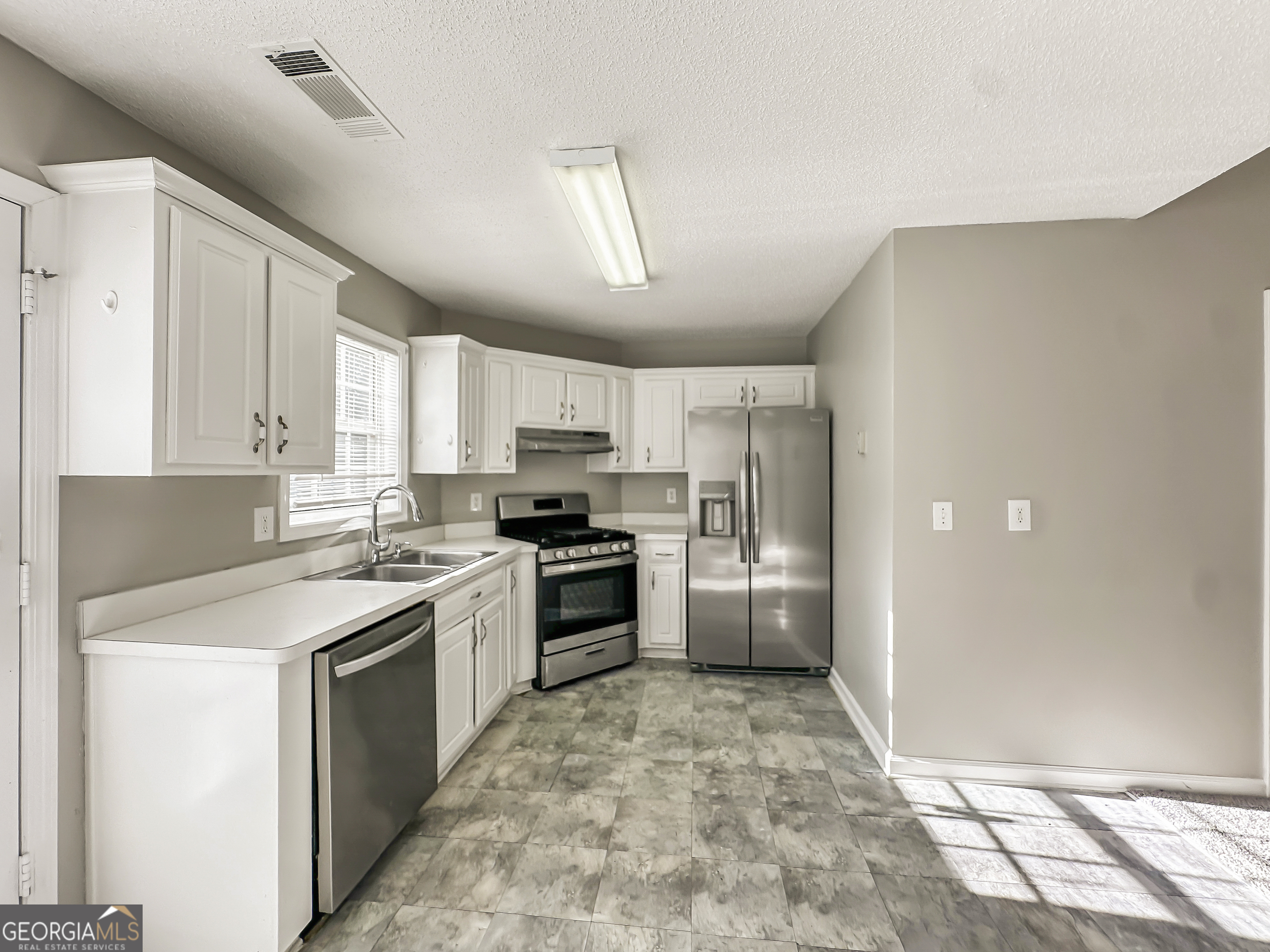 11084 Knotty Pine Place Hampton, GA 30228 - Photo 7 of 18 a kitchen with a stove a refrigerator and a sink
