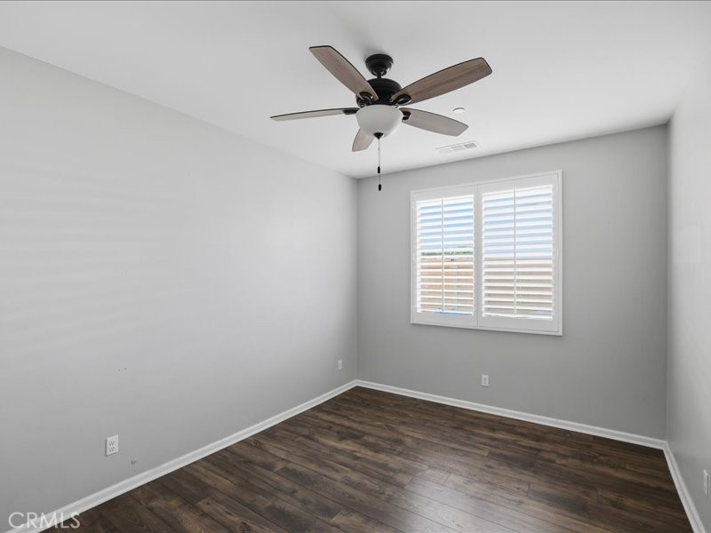 1569 Taurus Lane Beaumont, CA 92223 - Photo 16 of 33 an empty room with wooden floor fan and windows