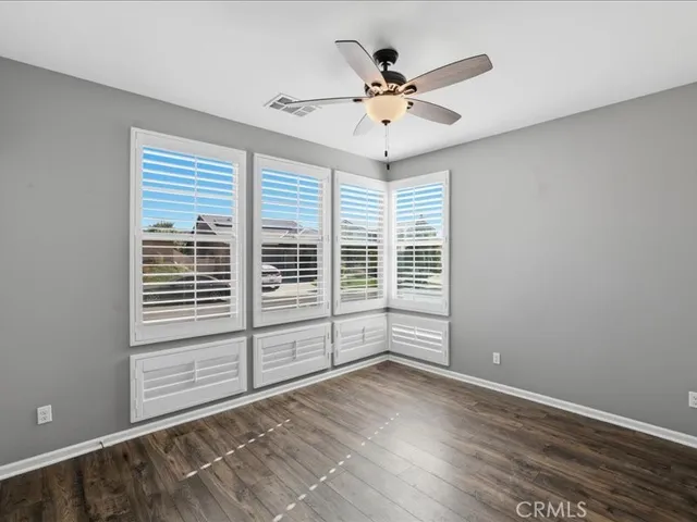a view of a livingroom with wooden floor and a ceiling fan