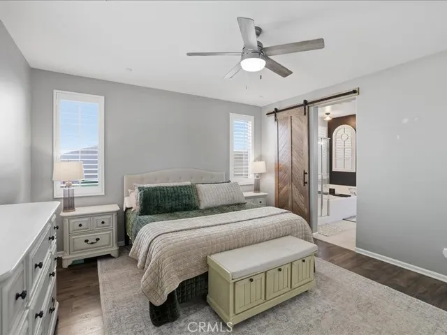 a bedroom with a bed a chandelier and a window