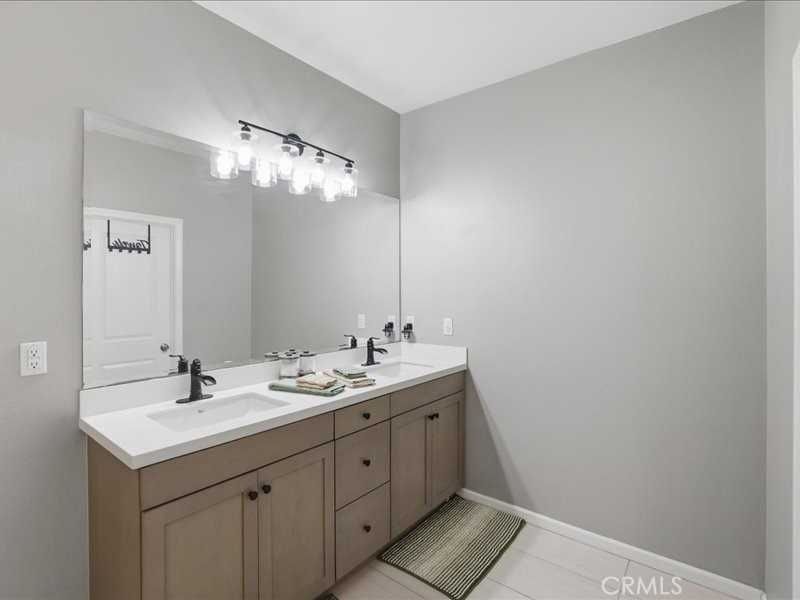 1569 Taurus Lane Beaumont, CA 92223 - Photo 24 of 33 a bathroom with a double vanity sink and a mirror