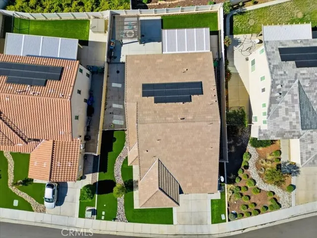 an aerial view of a house with a yard and large tree