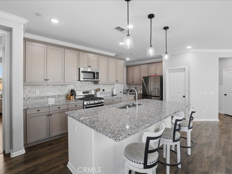 1569 Taurus Lane Beaumont, CA 92223 - Photo 7 of 33 a kitchen with stainless steel appliances granite countertop a stove top oven a refrigerator a sink and chairs