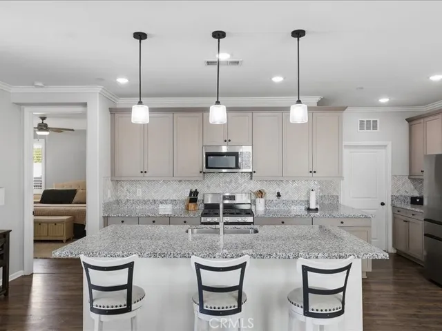 a kitchen with white cabinets and chairs