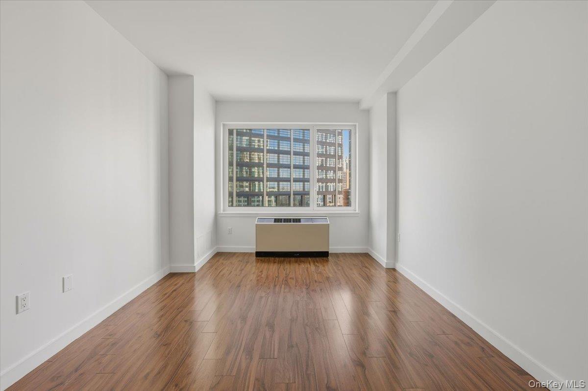 70 Fleet Street, Unit 19F Brooklyn, NY 11201 - Photo 11 of 32 wooden floor in an empty room with a window