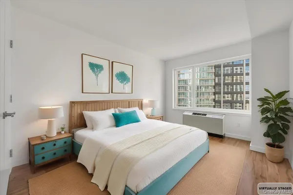 a bedroom with a large bed and a potted plant