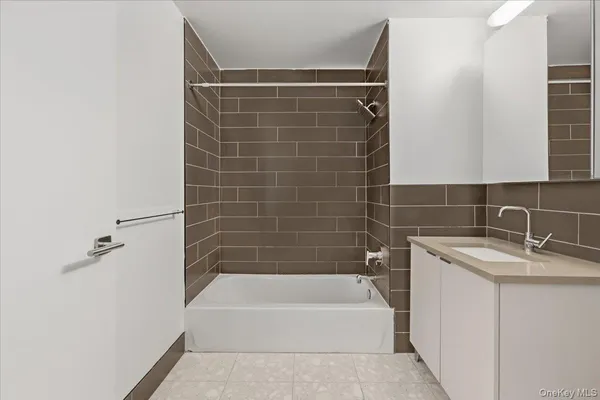 a bathroom with a granite countertop bathtub shower sink vanity and toilet