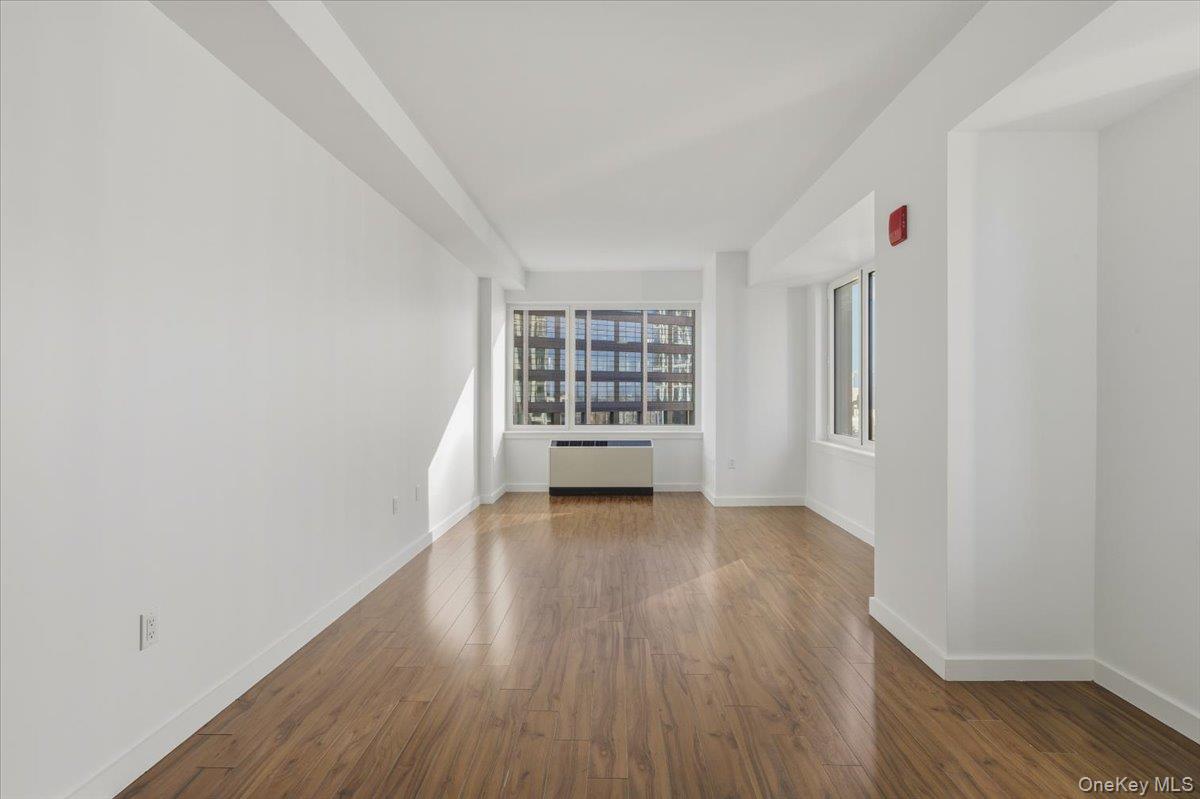70 Fleet Street, Unit 19F Brooklyn, NY 11201 - Photo 5 of 32 a view of an empty room with wooden floor and a window