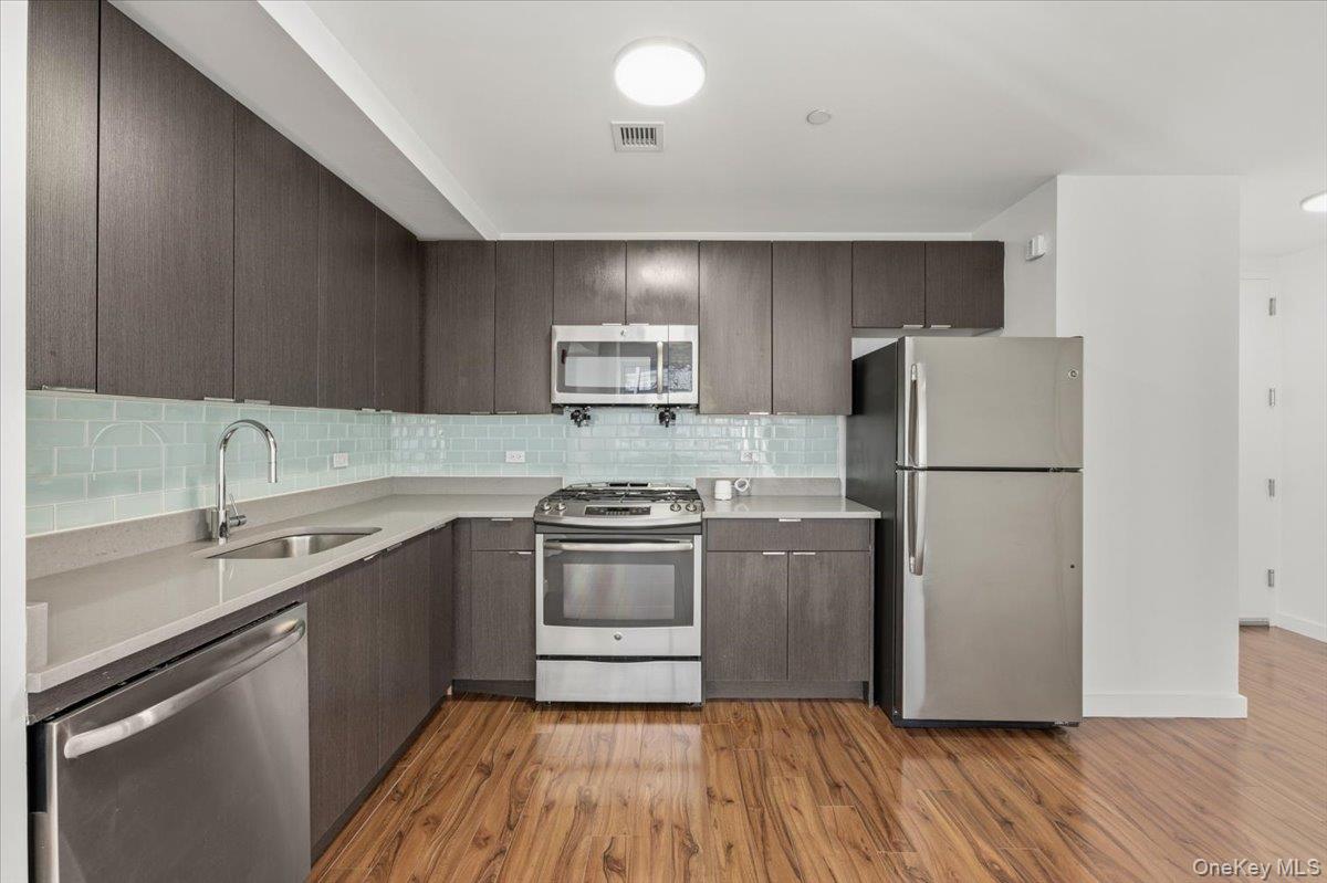 70 Fleet Street, Unit 19F Brooklyn, NY 11201 - Photo 8 of 32 a kitchen with a refrigerator sink and wooden cabinets