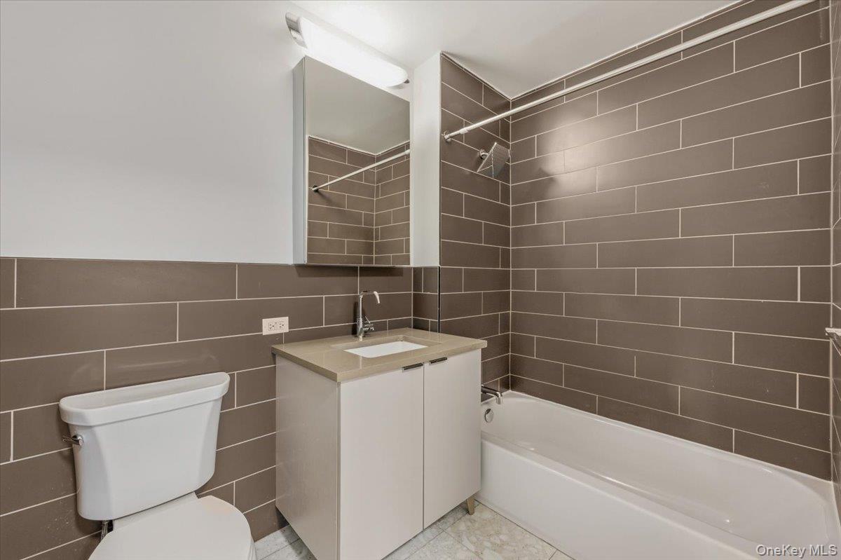 70 Fleet Street, Unit 19F Brooklyn, NY 11201 - Photo 9 of 32 a bathroom with a toilet a sink and mirror