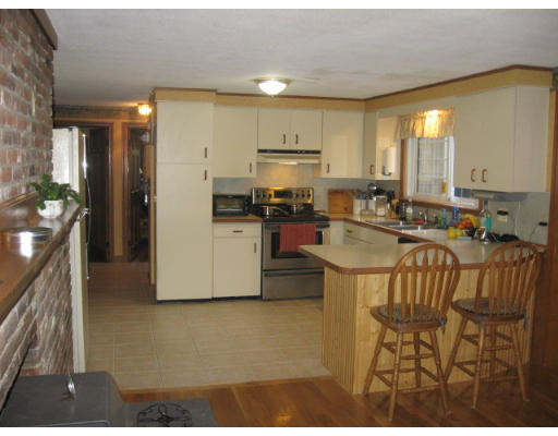 232 Worcester Road Princeton, MA 01541 - Photo 6 of 18 a kitchen with kitchen island a stove a refrigerator a sink and a dining table with wooden floor
