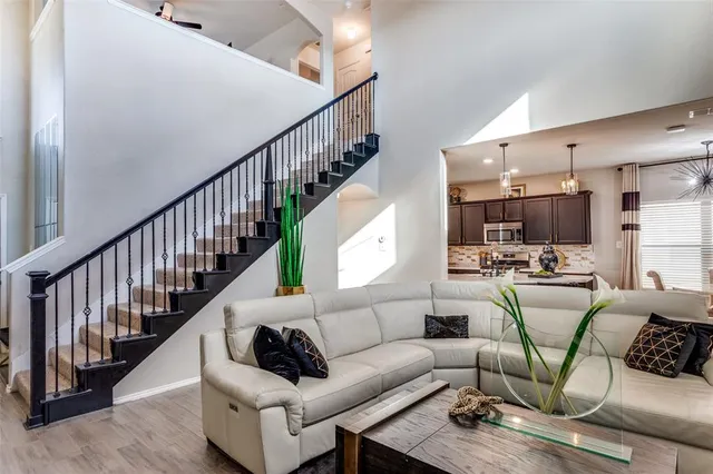 a living room with furniture kitchen view and a large window