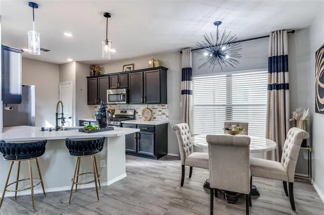 a kitchen with kitchen island stainless steel appliances a dining table and chairs