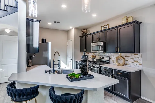 a kitchen with a sink cabinets and appliances