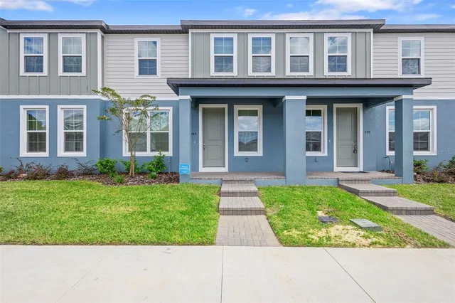 front view of a brick house with a yard