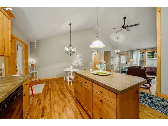 a view of a kitchen counter space a sink wooden floor and a chandelier